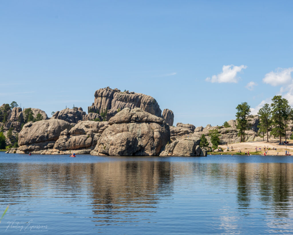 rock formations around lake with blue sky