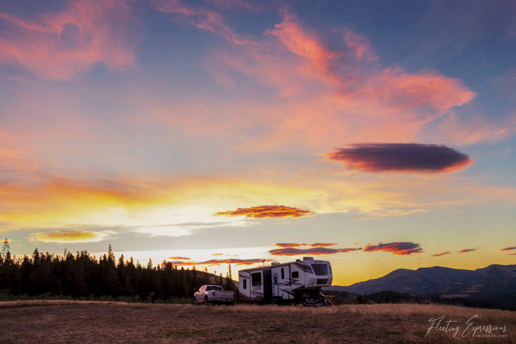 camping trailer with sunrise sky and trees