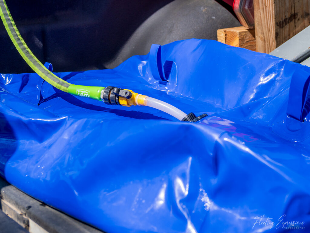 blue water container with hose attached